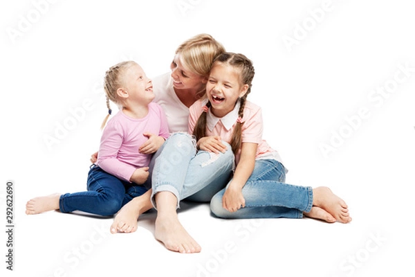 Fototapeta Mom and daughters are sitting and laughing. Love and tenderness. Isolated over white background.