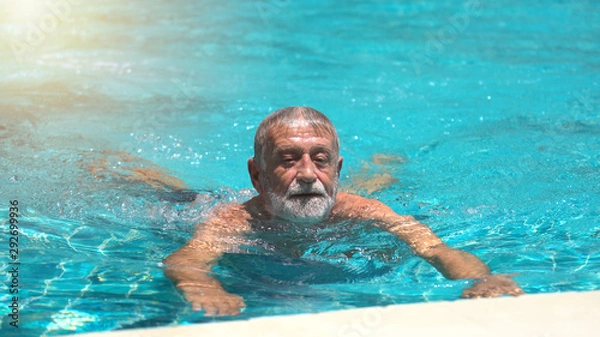 Obraz Senior man swimming in  swimming pool