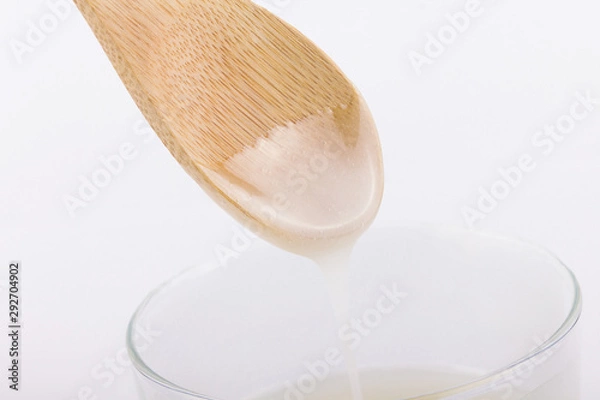 Obraz Inverted sugar syrup pouring from a spoon