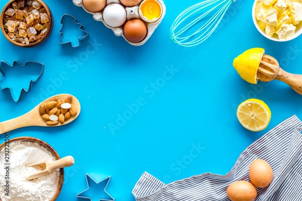 Fototapeta Cooking for Christmas or New Year dinner. Baking frame. Ingredients and utensil on blue background top view copy space