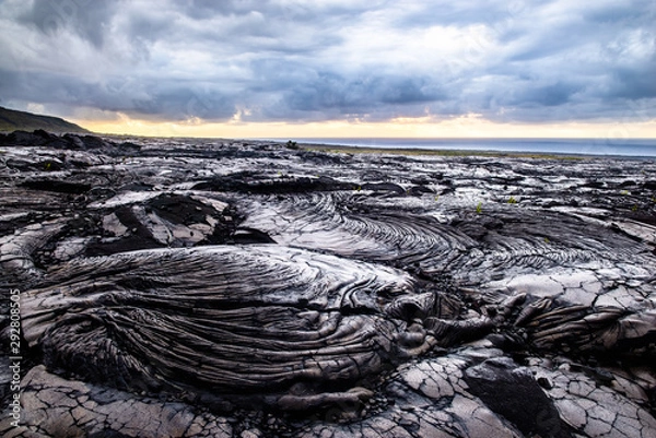 Fototapeta Dramatic Clouds over Cold Lava Field at Sunrise