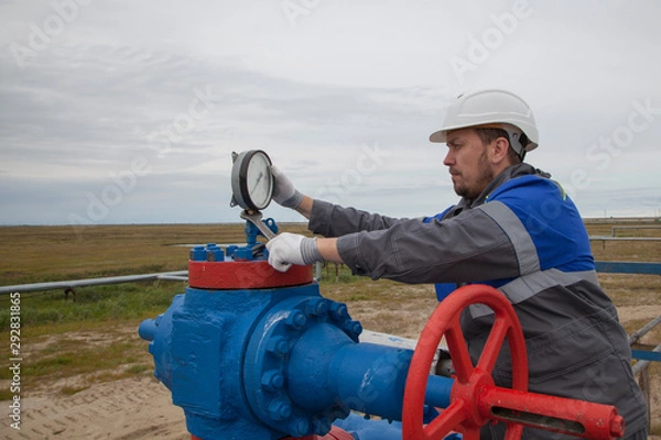 Fototapeta Gas operator, The operator operates the gas well with a torch.The mechanic - the repairman , Oil, gas industry. gas conditioning equipment and valve armature