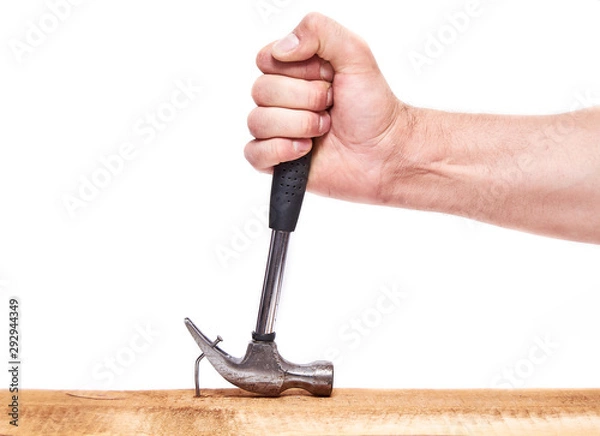 Fototapeta Hand pulls hammer nail out of the Board, on an isolated white background.