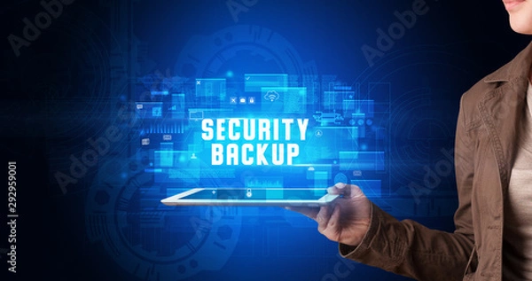 Fototapeta Young business person working on tablet and shows the digital sign: SECURITY BACKUP