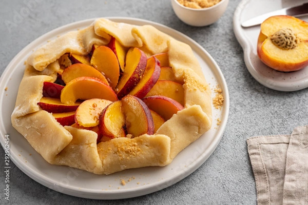 Fototapeta Appetite summer peach galeta on white table with copy space. summer open tart photo for cook book or food blog.