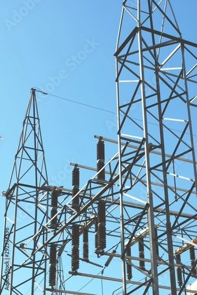 Obraz High voltage electrical insulators at a power station. Low angle shot against a blue sky.