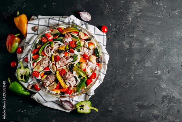 Fototapeta Meat with vegetables. Meat rolls with bacon. Baked vegetables, zucchini, tomato, pepper. Spices and herbs. Top view