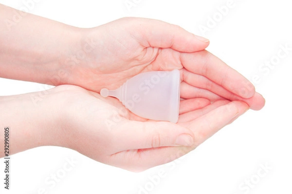 Fototapeta Eco-friendly hypelergenic gynecological silicone menstrual cup for women. Hygienic silicone bowl for collecting menstrual blood in the hands on a white background. Save money.