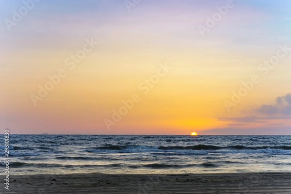 Fototapeta Sunset over the sea. Reflection of sunlight in the sea waves. The sky in the sunset rays.