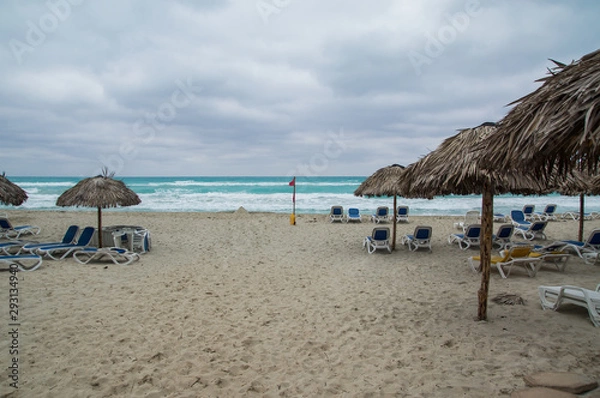 Fototapeta Deserted beach in bad weather, dark clouds over the sea.