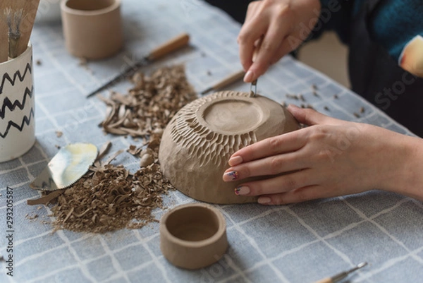 Fototapeta Pottery workshop, the process of making ceramic tableware, women's hands