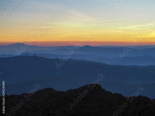 Fototapeta Beautifully graded twilight at Chiang Dao Mountain, the horizon line is orange. Many mountains are dark blue and light.