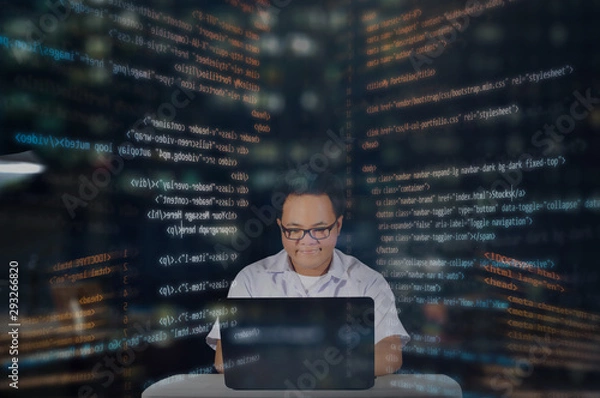 Obraz Young IT student giving a happy facial expression while doing his work coding for web development. Random HTML codes surrounding the web designer working late night concept. 