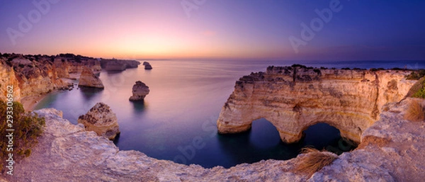 Obraz Niebieska godzina i wschód słońca wzdłuż wybrzeża Algarve w kierunku Faro z klifów nad Praia da Marinha w Portugalii
