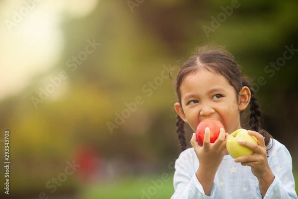 Obraz child eating apple little girl playing peek a boo holding fresh ripe apples