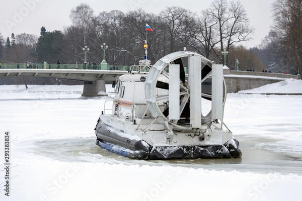 Fototapeta Boat hovercraft on white ice snow in winter.