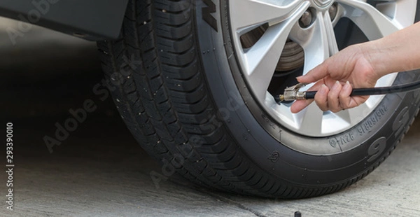 Obraz Inflating the tires and checking air pressure in service station.
