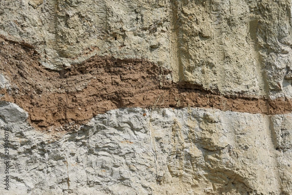 Fototapeta Texture of different layers of clay underground in a clay quarry. clay wall background close up