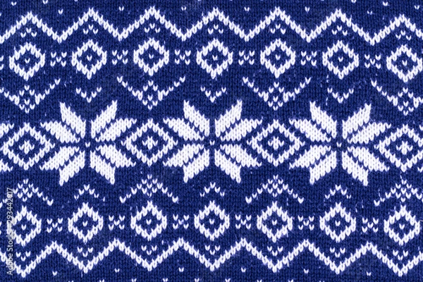 Fototapeta Warm Christmas blue sweater with snowflakes. Vintage Scandinavian Woolen Jumper Pattern. Closeup. Background. Knitting pattern with snowflakes.