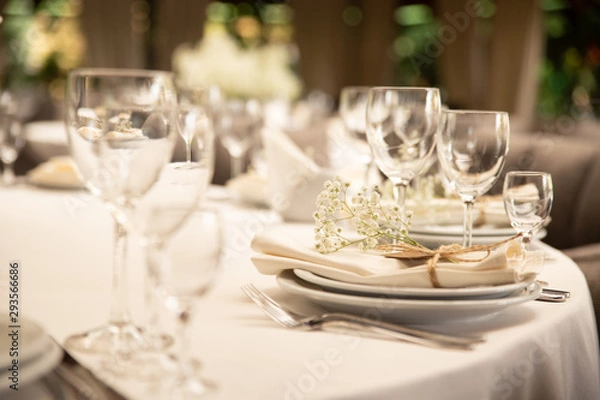 Fototapeta Table setting set with flowers. Modern and elegant decoration of table set for celebration with white utensil.