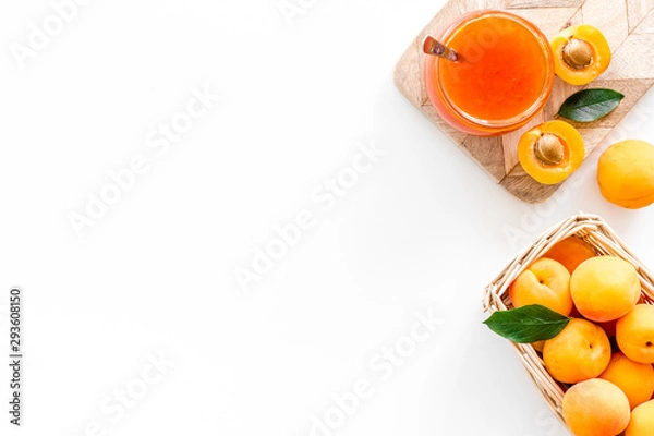 Fototapeta Summer preserves. Apricot jam in jar near fresh fruits on white background top view frame space for text