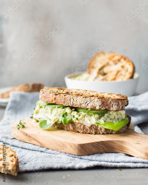 Obraz Sandwich with green beans hummus on a wooden board on a light background