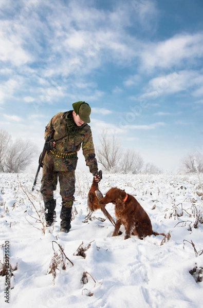 Fototapeta Hunter getting the pheasant from the dog