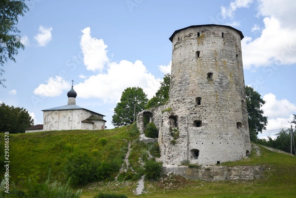 Fototapeta Fortress defensive tower next to the white church