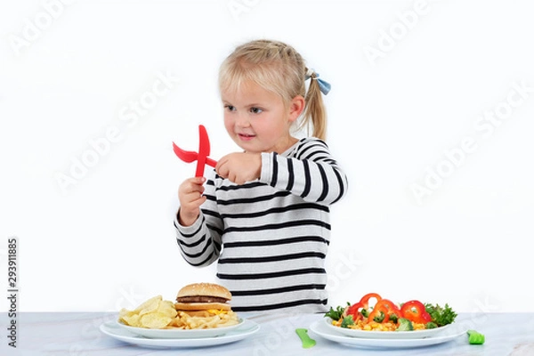 Obraz Little girl doesn't enjoy junk food.  Healthy food, especially vegetables full of vitamins are essential for the kid's menu.