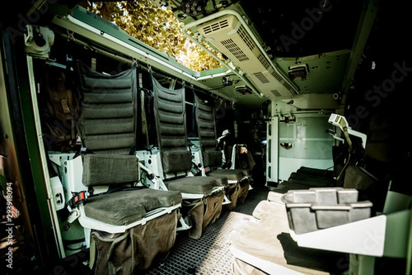 Fototapeta Multi-role armored military vehicle personnel carrier interior with empty chairs on both side carry up to eight infantry soldiers inside reconnaissance vehicle and equipped with remote weapons station