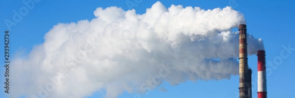 Fototapeta White smoke comes from pipes against blue sky. Problem harmful emissions and air pollution of central heating population of large cities eco concept