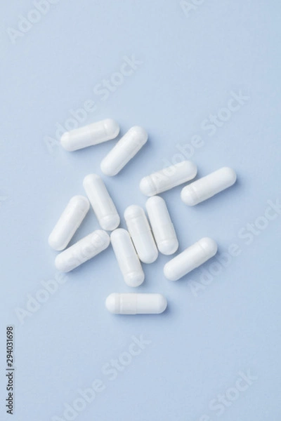 Fototapeta Arginine capsules. Bright paper background. Top view. Copy space. 