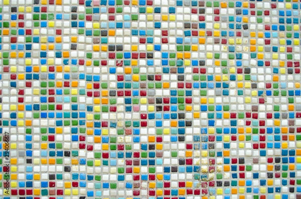 Fototapeta Bright multi-colored tile. Square color ceramic mosaic. Color optimistic background. Building decorative design concept. Place for text, lettering. Copy space. Selective focus image.