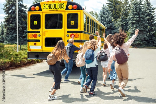 Fototapeta Being late. Classmates running to school bus back view waving to driver