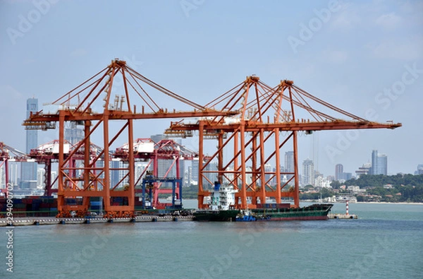 Obraz View on the container terminal and gantry cranes loading containers on the cargo ship in the port of Xiamen, China. 