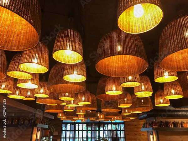 Obraz original room lamps in wicker shades with a pleasant warm light in a cozy rustic country style interior
