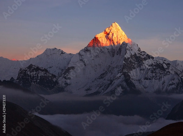 Fototapeta Last rays of sun at sunset mount; figuratively, the disappearance of hope, dissolution of all light in the dark, the victory of the forces of darkness over the forces of light. Ama Dablam peak (6856m)