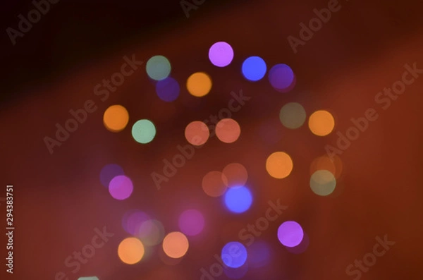 Fototapeta Night city lights on Christmas night. New Year, colored garland in defocus. Multi-colored bokeh on a dark background for photoshop.