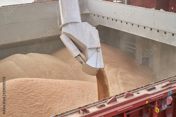 Obraz Grain loading in hold of bulk carrier ship with elevator crane closeup. Port grain elevator. Industrial sea trading port bulk cargo zone grain terminal