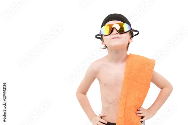 Obraz Smart kid in swimming shorts and black hat and goggles on head with orange towel on neck