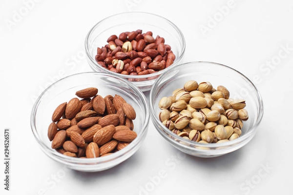 Fototapeta peanuts, almonds and pistachios in bowls on white background