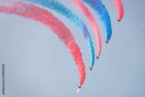 Obraz Jets fly, leaving an arc of red and blue smoke