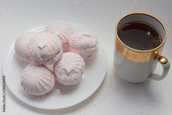 Obraz still life pink marshmallow on a white plate and a cup of tea