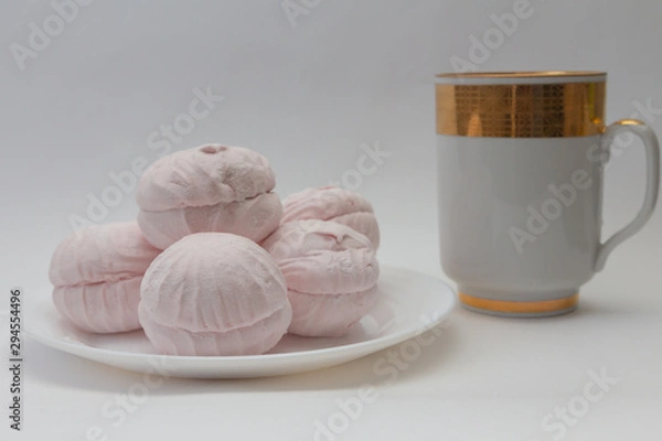 Obraz still life pink marshmallow on a white plate and a cup of tea