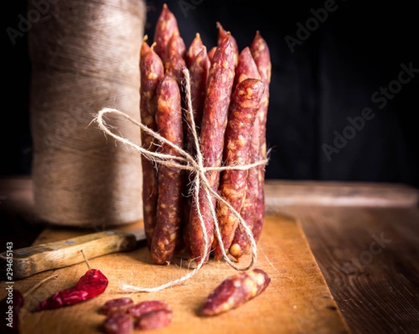 Fototapeta Thin uncooked smoked pork and beef sausages. Delicatessen meat.
