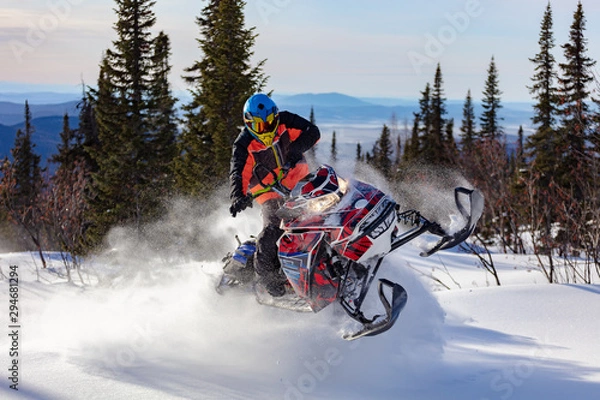 Obraz In deep snowdrift snowmobile rider make fast turn. Riding with fun in deep snow powder during backcountry tour. Extreme sport adventure, outdoor activity during winter holiday on ski mountain resort