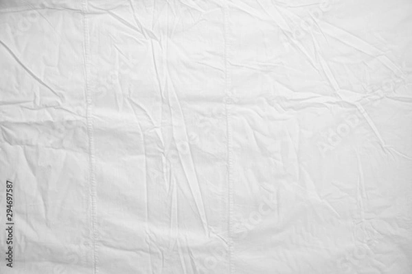 Fototapeta White Crumpled Bed Sheet Background Texture. white fabric top view. pleats on light fabric