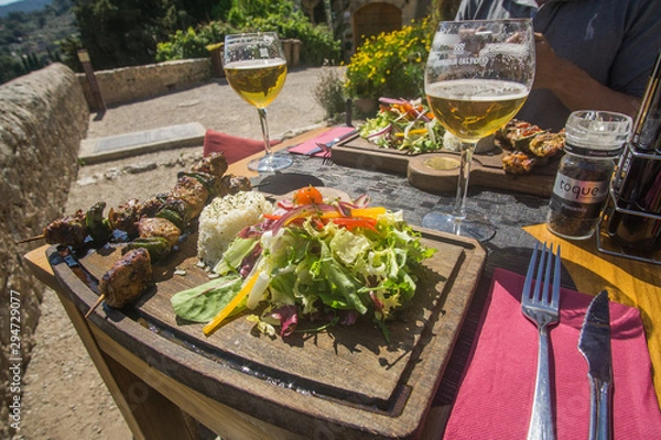 Fototapeta Beer and skewers on Lunch time in a restaurant that have a beautiful view of the valley and mountains at the village of Valldemossa in Palma de Mallorca Spain. 