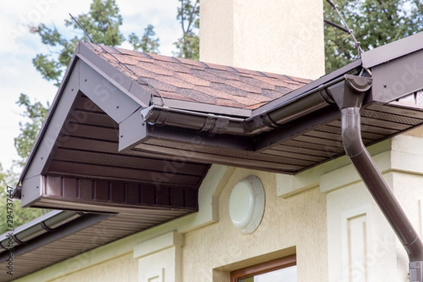 Fototapeta brown roof visor drain gutter on a light building with a white lampshade.