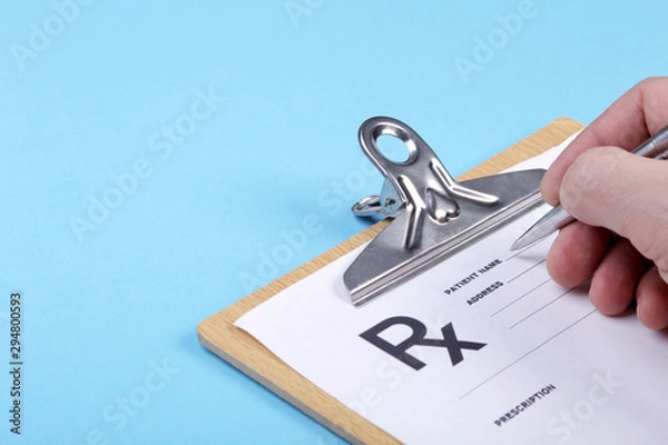 Fototapeta Male doctor filling patient complaints list clipped to pad. Physical, exam, disease prevention, ward round, prescribe remedy, healthy lifestyle concept.